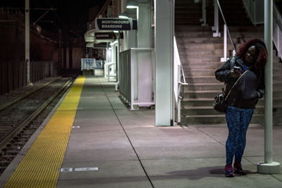 Rear view of man standing at railroad station