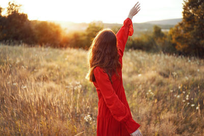 Rear view of woman standing on field