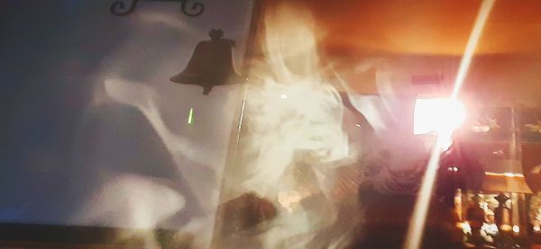 Blurred motion of person standing in illuminated building