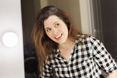 Portrait of a smiling young woman at home