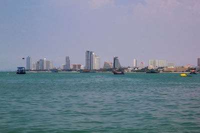 Sea by buildings against clear sky