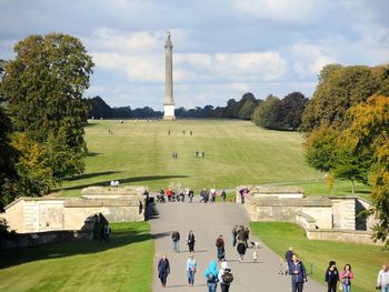 Tourists at park against sky