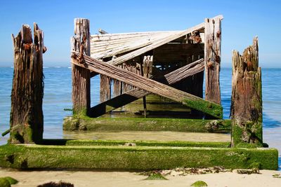 Wooden pier over sea against clear sky