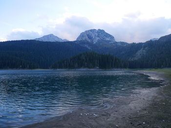 Scenic view of lake by mountains against sky