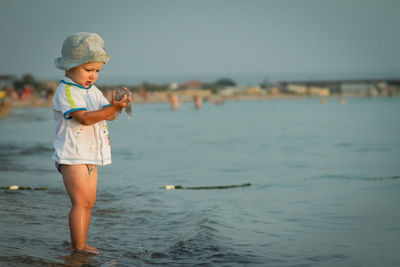 Boy holding jellyfish in sea