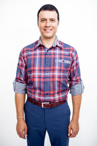 Portrait of young man standing against white background