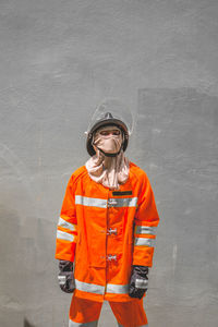 Firefighter standing against wall