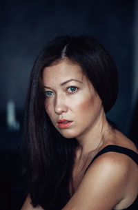 Close-up portrait of serious mid adult woman sitting at home