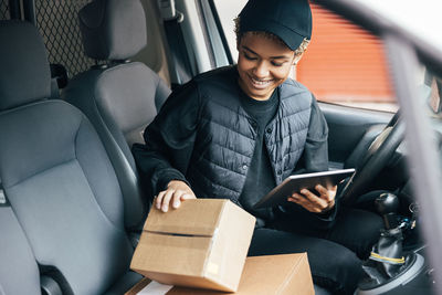 Full length of man using mobile phone while sitting in car