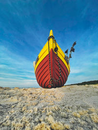 Low angle view of yellow umbrella on beach against sky