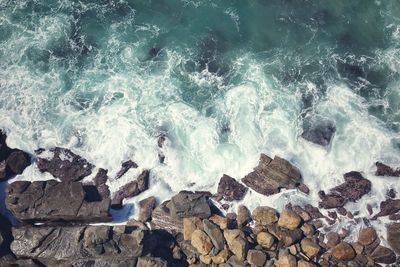 High angle view of waves breaking on rocks at shore