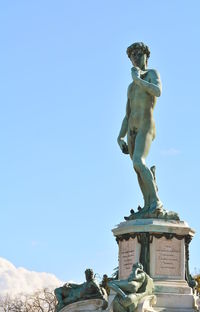 Low angle view of statue against blue sky