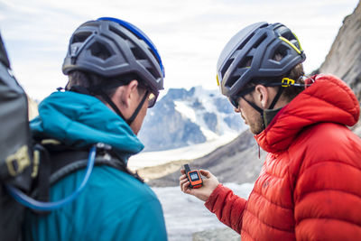 Two climbers use a gps to navigate mountain terrain.