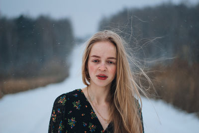 Portrait of young woman standing on snow