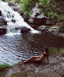 Full length of boy on rock in water