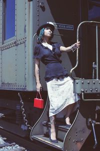 Portrait of young woman standing on train