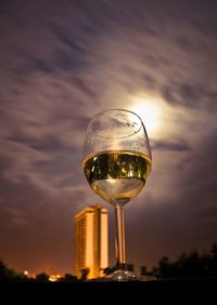 Close-up of beer glass against sky during sunset