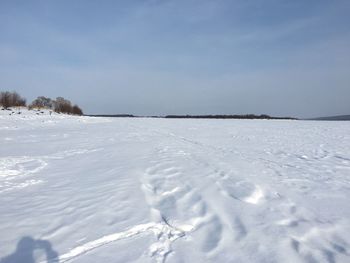 Snow covered land against sky