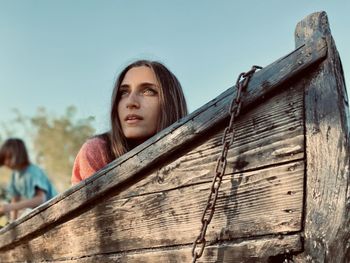 Portrait of young woman in a boat looking away against sky