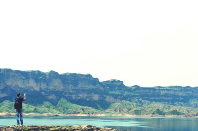 People on cliff at riverbank