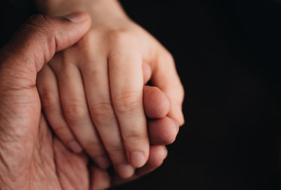 Cropped hand of person against black background