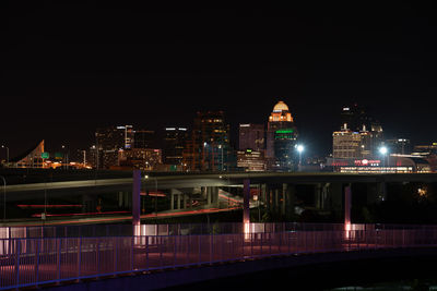 Illuminated modern buildings against sky at night