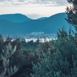 Scenic view of townscape by mountains against sky