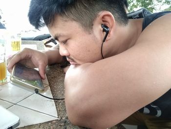 Portrait of shirtless boy looking at table