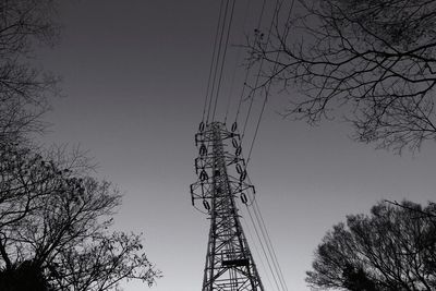 Low angle view of silhouette electricity pylon against sky