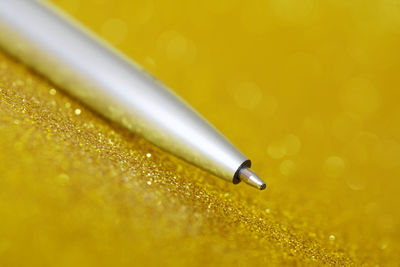 Close-up of water drops on yellow pen