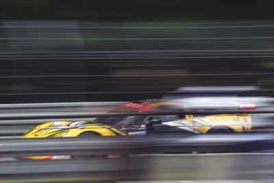 Blurred motion of yellow car on road