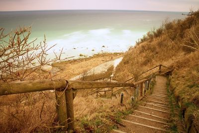 Old wooden stair way down with wooden hadrail, steps down to sea shore hill. cap arkona, germany