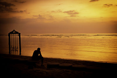 Silhouette people on beach against sky during sunset