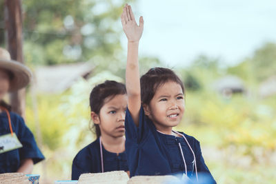 Portrait of boy with arms raised in park