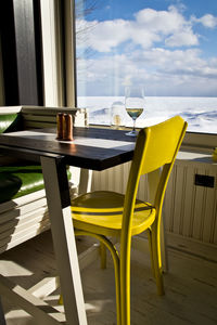 Table with yellow chair and a view onto frozen lake ontario