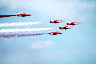 Low angle view of airshow against sky