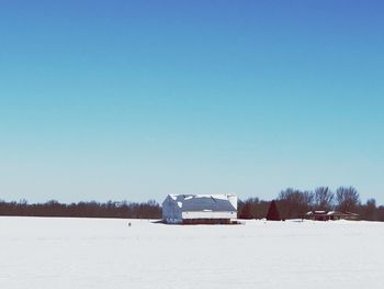 Scenic view of snow covered field against clear blue sky