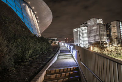 Bridge over canal amidst buildings in city at night