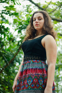 Young woman against tree