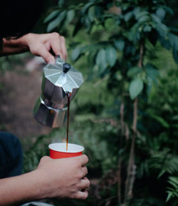 Midsection of person holding ice cream cone outdoors