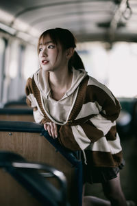 Portrait of young woman sitting in train