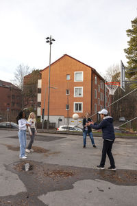 Teenage friends playing basketball outdoors