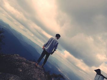 Man climbing on mountain road against sky