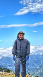 Portrait of man standing against blue sky