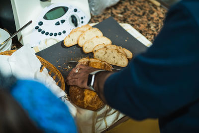 High view of man cutting bread in kitchen