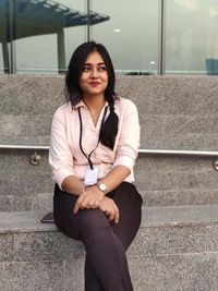 Portrait of a smiling young woman sitting outdoors