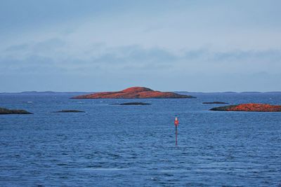 Person standing in sea against sky