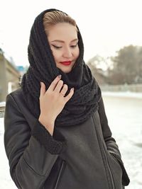 Close-up of beautiful woman standing against snow