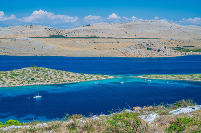 Scenic view of sea and mountains against sky