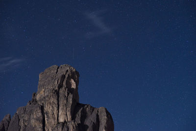 Low angle view of rock formation against sky at night